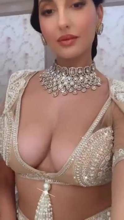 Bollywood actress Nora Fatehi showing ample cleavage in stylish outfit.