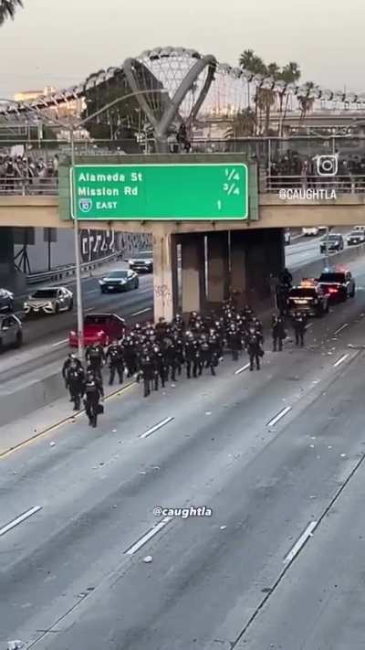 Video: Protesters throw rocks at CHP officers from L.A. freeway bridge.