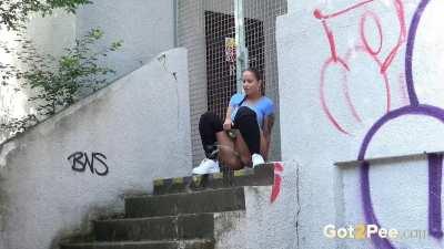 Busty brunette sprays her golden piss down over the steps beneath her