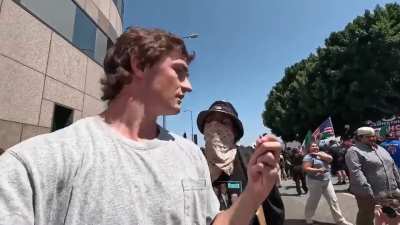 YouTuber is confronted by protester.