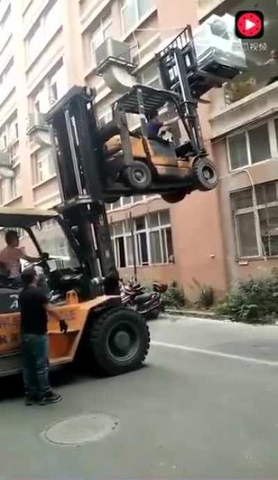 Loading the printer with two forklifts