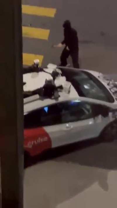 This person vandalizing a self-driving Cruise car with a hammer in San Francisco 