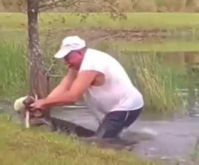 A Man Opens Up A Crocodile's Jaw With His Bare hands to Free A Dog