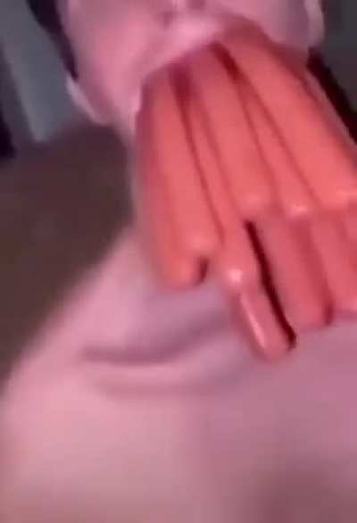 Man with a bunch of hotdogs in his mouth