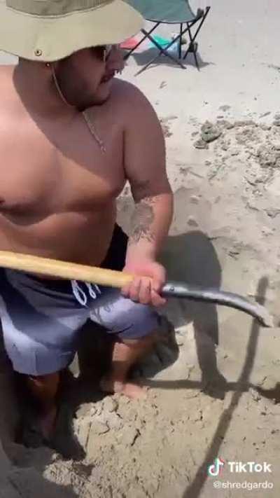 2 guys digging a hole at the beach