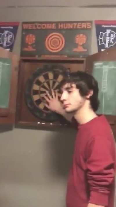 Dumbass stands in front of a darts board, outcome is... not as he expected it.