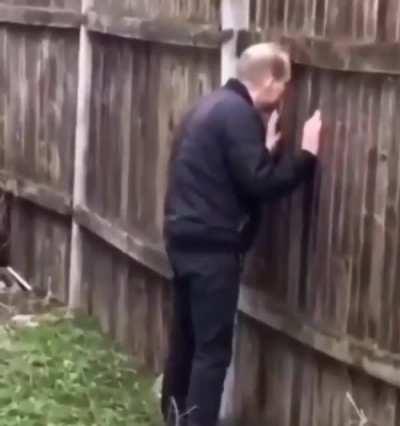 Just a man looking through a hole in the fence