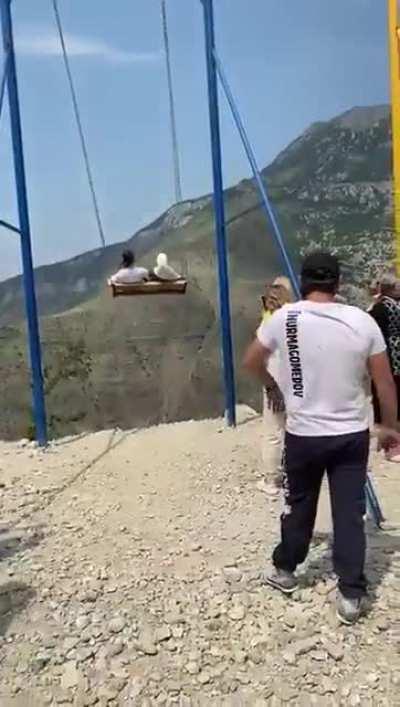 Swinging on a sketchy cheap playground swing set on the edge of a cliff