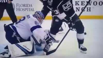 Lightning Goaltender Andrei Vasilevskiy looks between his opponent's legs to locate puck and make behind the back glove save