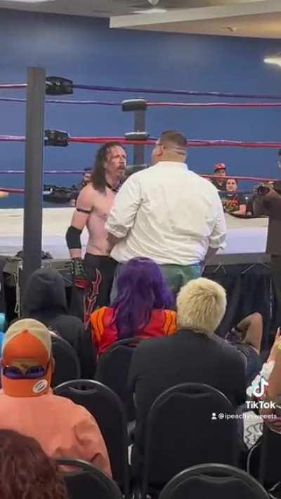 Peter Griffin slams a wrestler while Misato watches