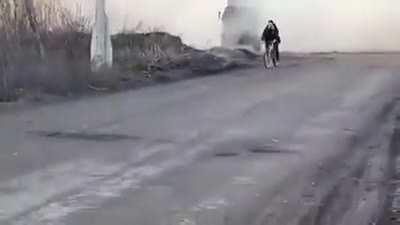 Ukrainian HIMARS launch as a cyclist casually rides past.