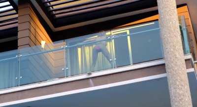 Masturbating in full view from her balcony