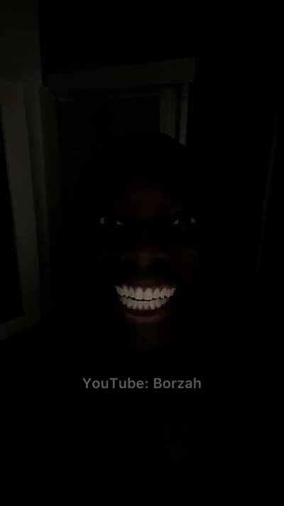 Black man smiling in dark room