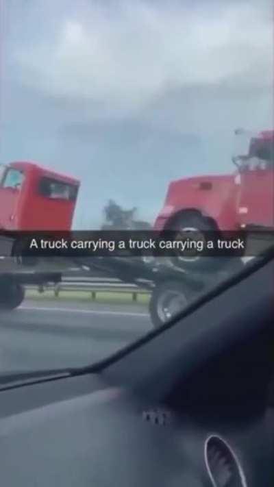 A TRUCK CARRYING A TRUCK CARRYING A TRUCK CARRYING A TRUCK