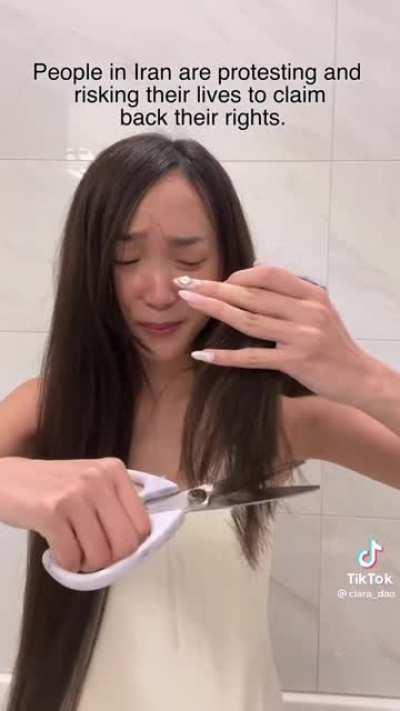 Trimming her hair while fake crying to hop on the trend.