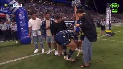 Jason Taumalolo cuddles his dog before his 200th game