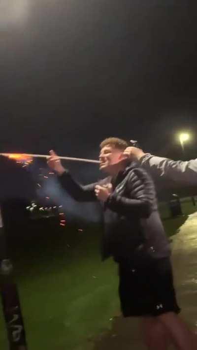 Holding a firework with the teeth 