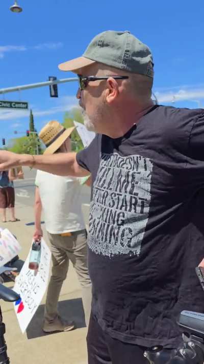 MAGA dude tries to harass peaceful protesters. The defeated male then leaves.