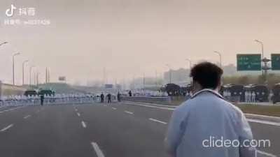 Foxconn workers in China marching on highway fleeing from a massive COVID outbreak face off against a defensive line of hazmat-clad epidemic force
