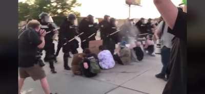 Cops escalate peaceful protest. People sitting on the ground getting walked over for no reason.