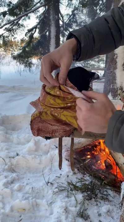 This raven being covered up in a blanket by the fire