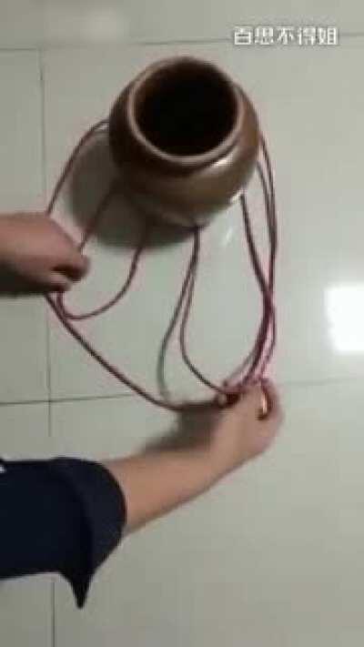 Using a single piece of string to securely carry a clay pot