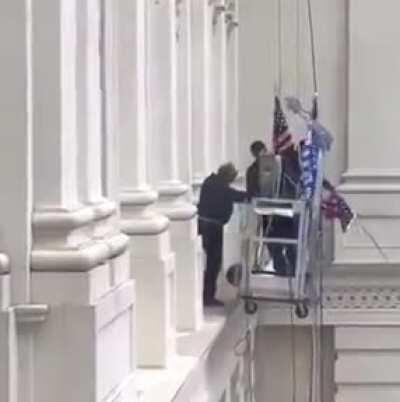 Replacing an American flag with a Trump flag...