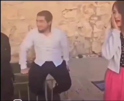 A tourist lady tries to take pictures in Israel, gets slapped by a random man while the men besides her laugh 