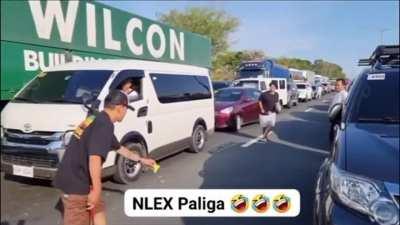 Due to slow heavy traffic, motorists play badminton to pass the time