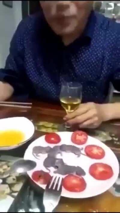 Chinese man eating some mouses