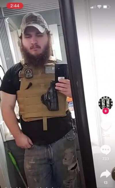 Fat guy with empty holster throws up the white power hand symbol