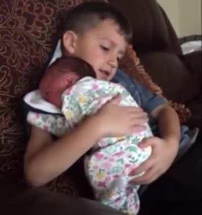 Just a big brother burping the baby