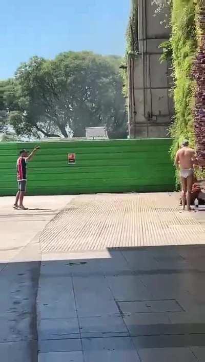 Un hincha de chacarita explicándole a un yanki que no se puede bañar en el medio de aeroparque 