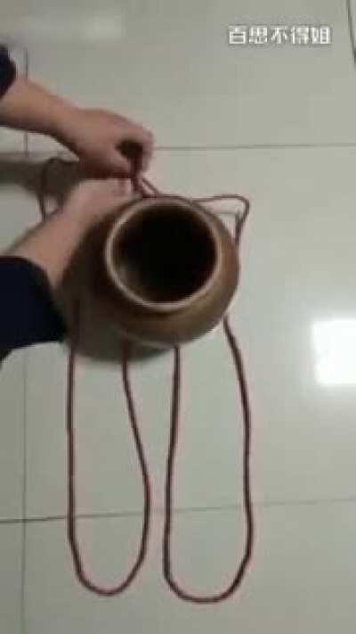 Using a single piece of string to securely carry a clay pot