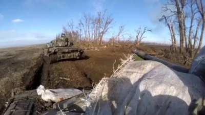 Two Russian tanks assaulting a trench in a treeline, point blank range