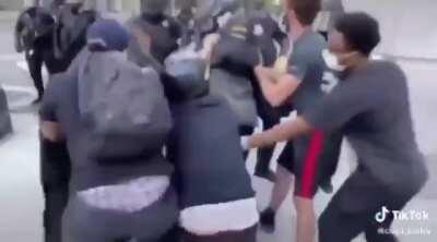 Protesters turn over a rioter to the police