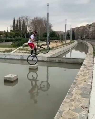 Jumping a wheelie bike across water channel