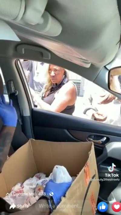 Lady throws back food at woman feeding her