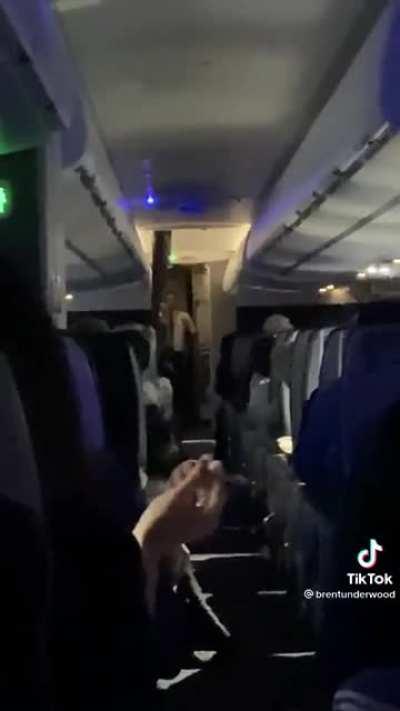 Flight attendant shames a group of unruly passengers that were abusing the crew after a long flight delay