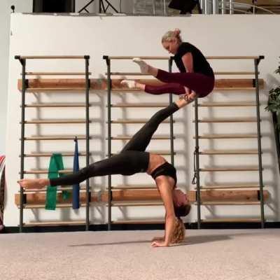 Two female gymnasts demonstrating strength and perfect balance