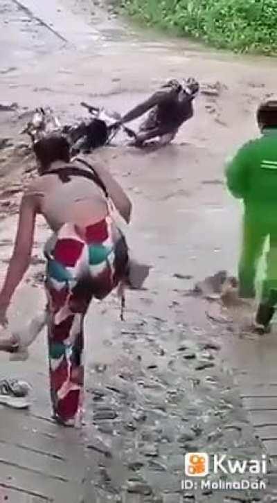 Guy tries to cross flooded road on bike