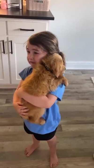 Little girl sobs as she holds her new puppy