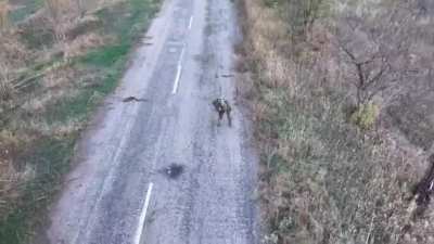 RU POV: Russian drone films a Ukrainian soldier with his fingers blown off trying to put a tourniquet at his legs.