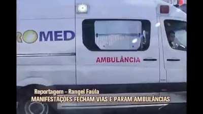 ambulance crosses fire barrier (made by protesting traders) to take a patient with suspected stroke.