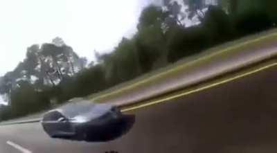 Driver tries to race a biker and his gf pulls the handbrake to stop him