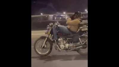 Dude on highway ride taking a quick nap on his motorcycle