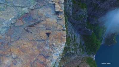 sitting athe the edge of this huge cliff in norway