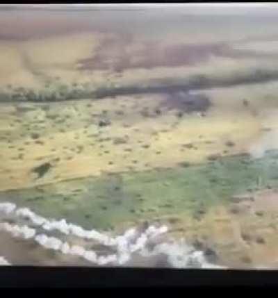 A Ukrainian drone operator films the exact moment an MI-24 helicopter fires its unguided rockets toward the Russian positions. The projectiles pass the drone in very close proximity.