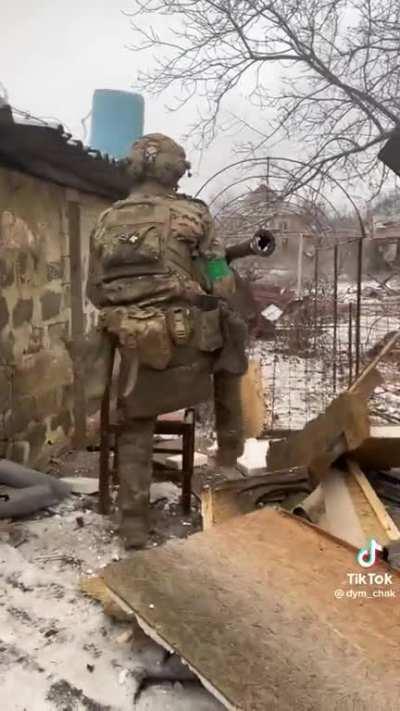 A Ukrainian firing at Russians / Wagner troops with an RPG-7, assisted by a tactical chair 