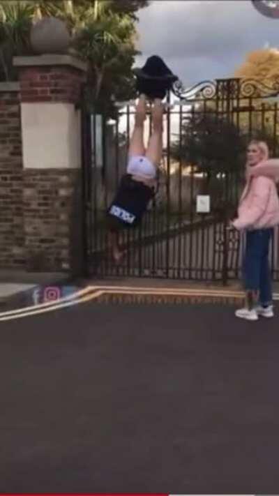 Cop poops💩 his tighty-whitey's as he struggles upside-down to free himself when pants are caught on fence. Onlookers point, laugh, and urge other bystanders not to help him down